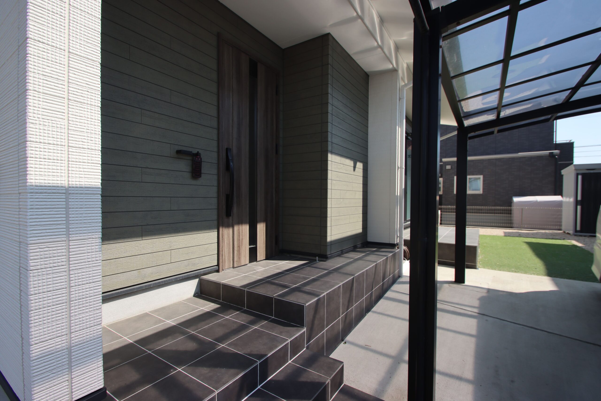 グリーンのアクセント壁が目を引く玄関まわり◎荷物かけもあって帰宅時に便利!